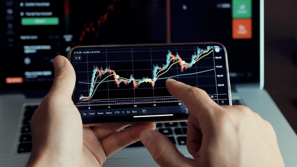 Man looking at stock graph on mobile phone