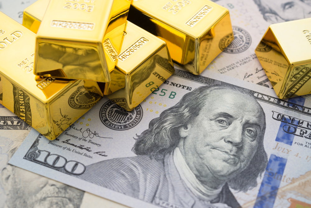 Gold bars on US dollar bill banknotes background. Concept of gold future trading, online asset commodity trading or buy gold bars for investment.